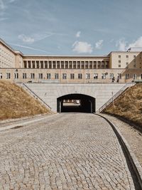 Footpath by historic building against sky