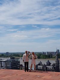 Woman standing by built structure against sky