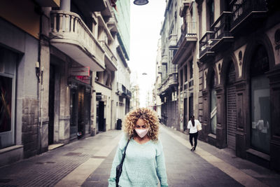 Portrait of woman standing on street in city