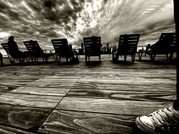 Silhouette people walking on footpath against sky
