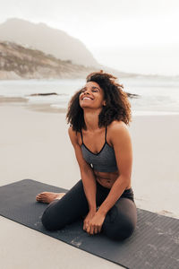 Portrait of young woman sitting on beach