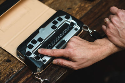 Close-up of hand holding camera on table