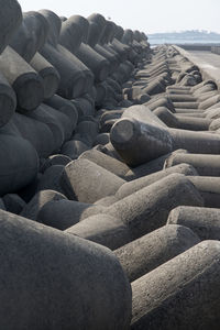 Stack of tetrapods on beach against sky