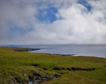 Scenic view of calm sea against cloudy sky