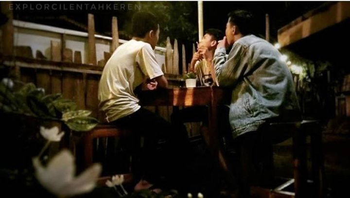 SIDE VIEW OF A MAN SITTING IN A RESTAURANT