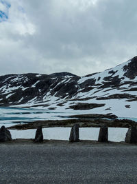 Scenic view of lake by snowcapped mountain against sky