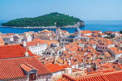 High angle view of townscape by sea against clear sky