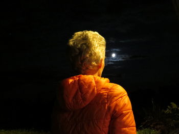 Close-up of illuminated man against sky at night