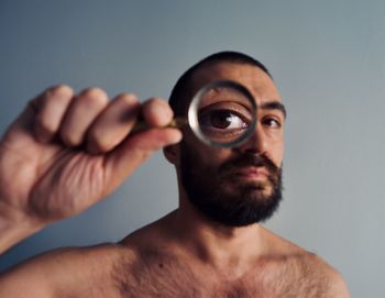 Low angle view of young man wearing mask against wall