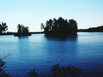 Scenic view of lake against clear sky at sunset