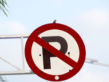 Low angle view of no parking sign against sky