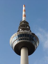 Low angle view of communications tower against blue sky