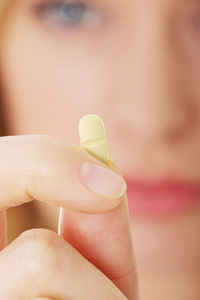 Young woman holding pill