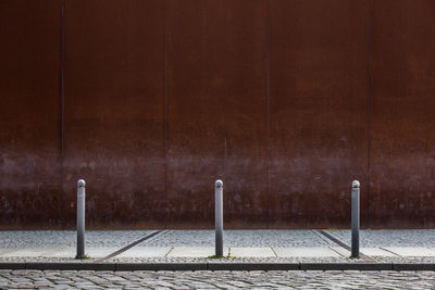 Empty street and footpath against wall