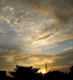 Silhouette of trees against cloudy sky