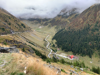 Scenic view of road by mountains against sky