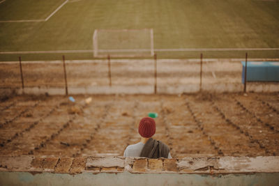 Rear view of person in empty soccer stadium