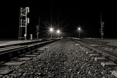 Black and white late night long exposure of a railway crossing a busy highway