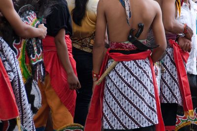 Rear view of people wearing traditional clothing standing outdoors