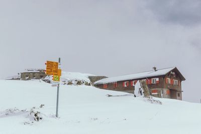 Built structure on snow covered landscape against sky