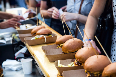 Street food many burgers with meat and cheese and french fries in craft packaging. 