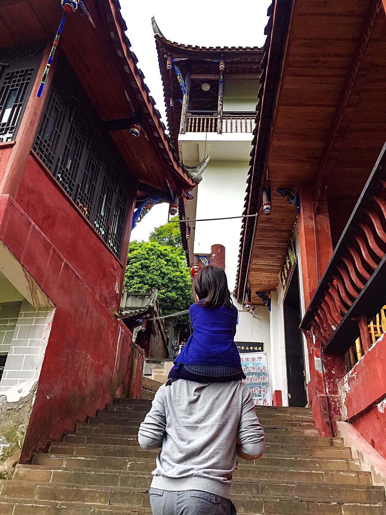 Kid ride on parent's shoulders