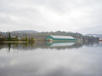 Scenic view of lake by buildings against sky