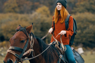 Young woman riding horse