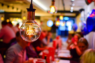 Close-up of illuminated light bulb in restaurant