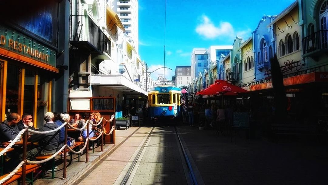 architecture, building exterior, city, group of people, built structure, transportation, mode of transportation, crowd, large group of people, real people, women, men, street, public transportation, sky, rail transportation, city life, adult, lifestyles, track, outdoors, waiting