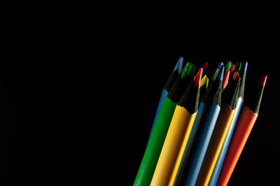 Close-up of colored pencils against black background