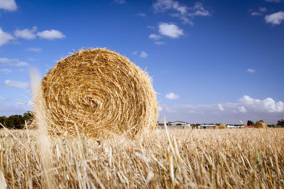 Hay bales on field against sky