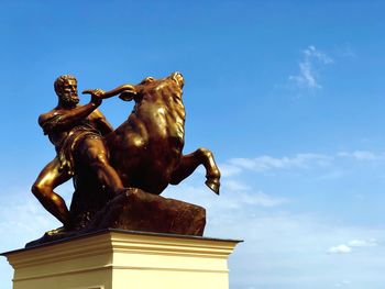 Low angle view of statue against blue sky