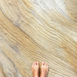 Low section of person standing on sandstone