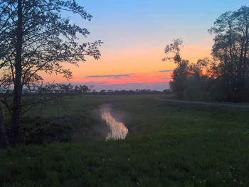 Scenic view of field against sky during sunset