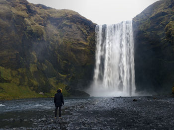 Single person in front of skógafoss in iceland 