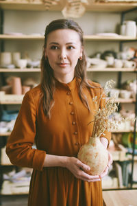 Portrait of smiling young woman standing in store