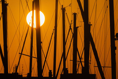 Silhouette of sailboats at harbor during sunset