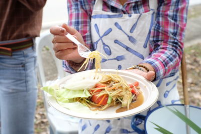 Midsection of woman holding papaya salad