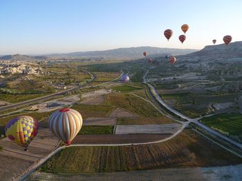 Hot air balloon flying over land against sky