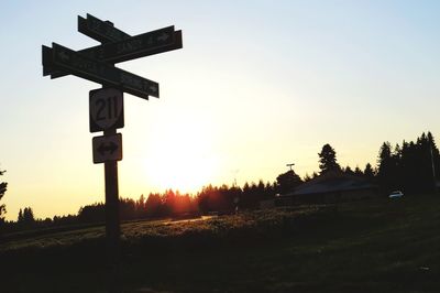 Information sign on field against sky during sunset