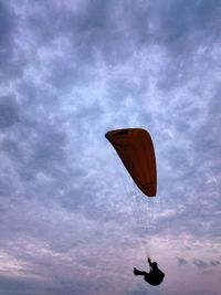 Low angle view of airplane flying against cloudy sky