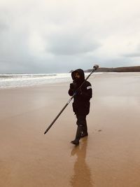 Full length of man standing on beach against sky