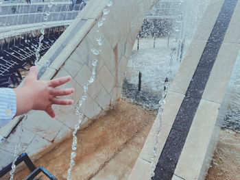 High angle view of person holding wet glass