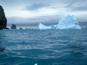 Sea and iceberg against mountain in antarctica