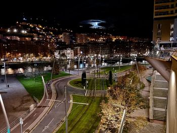 High angle view of illuminated street amidst buildings at night