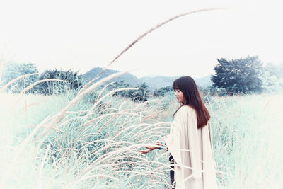 Woman standing by palm tree