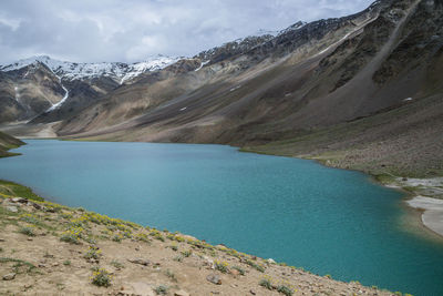 Scenic view of lake by mountains against sky