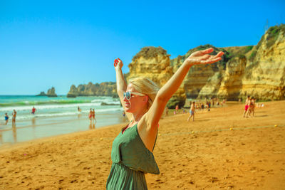 Woman with arms outstretched standing at beach