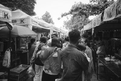 Rear view of people standing on street market